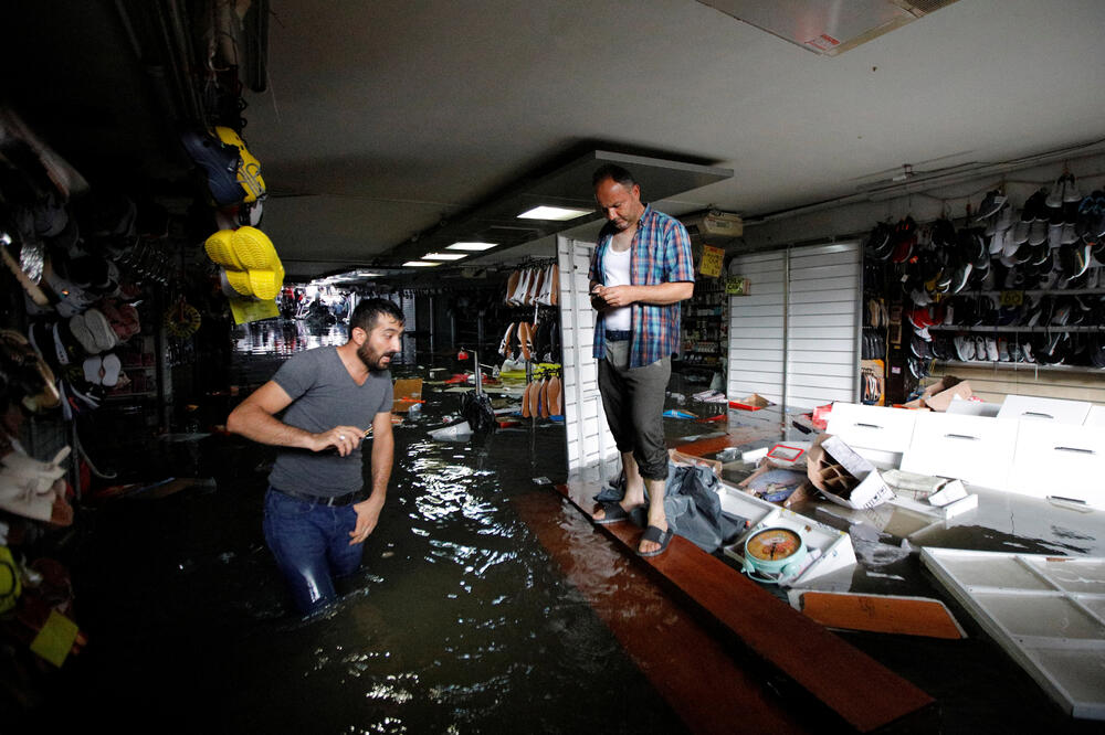 Vlasnici radnji pokušavaju spasiti robu, Foto: Reuters