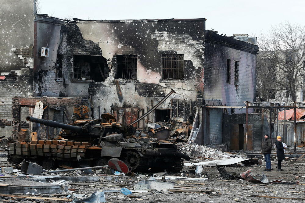 Lokalni stanovnici pored uništenog oklopnog vozila u Volnovahi, Foto: Reuters