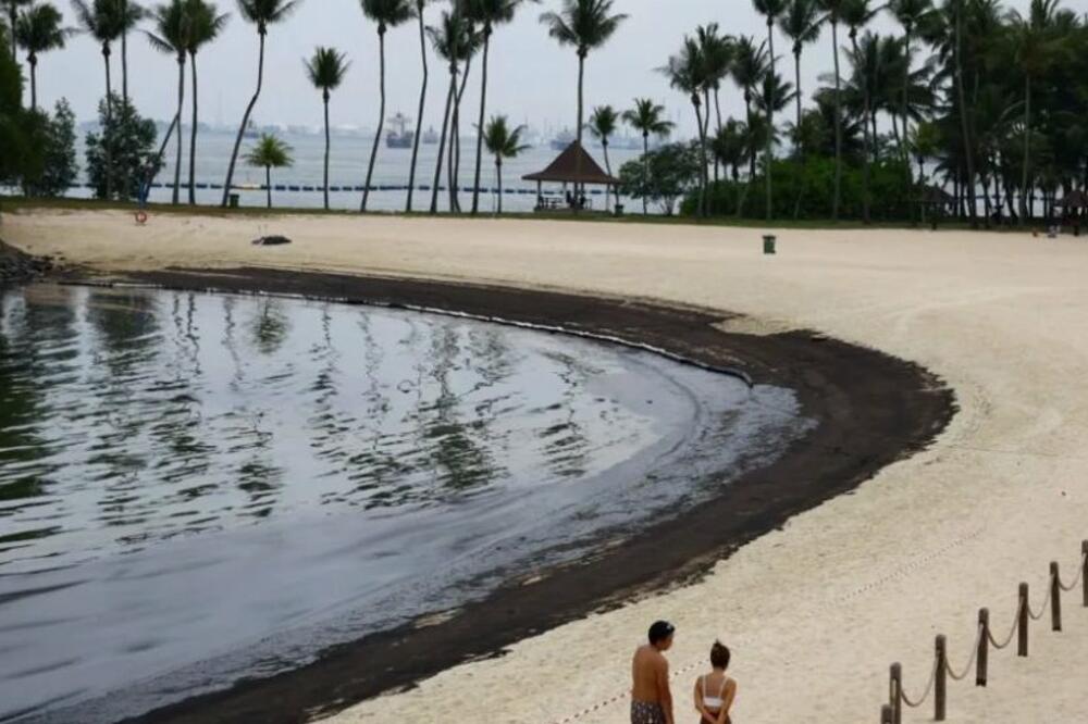 Ljudi šetaju na plaži Tanjong pored naftne mrlje, Foto: Reuters