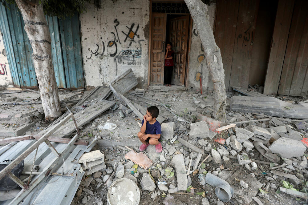 Dječak sjedi u kući uništenoj izraelskim bombardovanjem, Foto: REUTERS