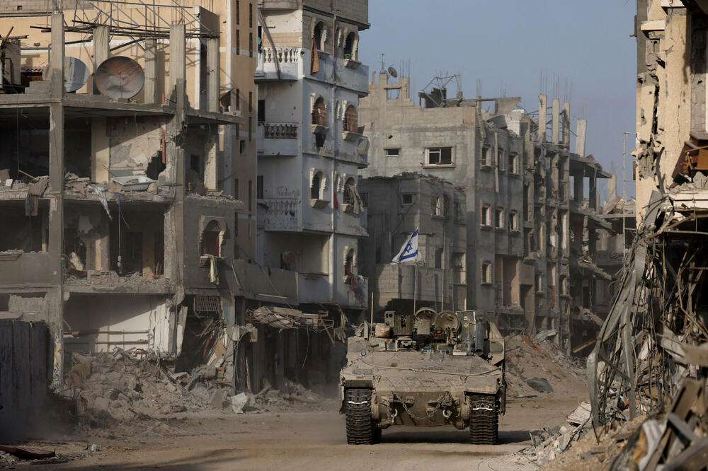 Izraelsko oklopno vozilo među uništenim zgradama u Gazi, Foto: REUTERS