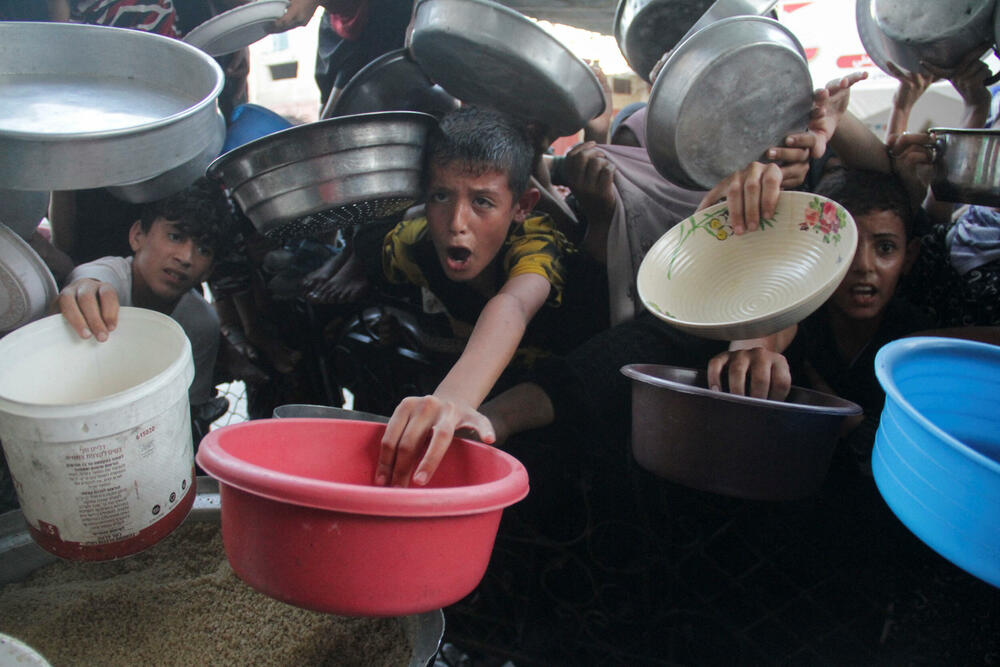  Palestinci preuzimaju hranu pripremljenu u humanitarnoj kuhinji